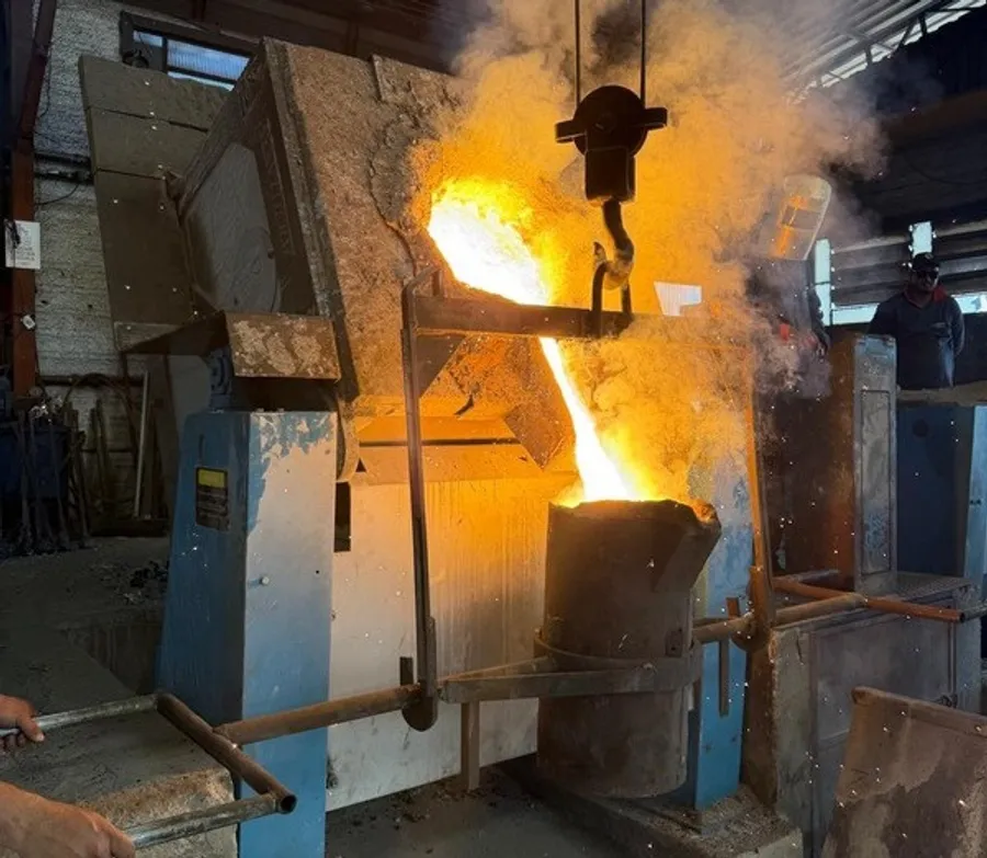 Metal líquido sendo vazado do forno para a panela